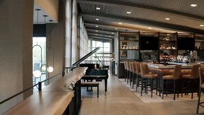 Un intérieur moderne avec un piano, un coin bar et des sièges.