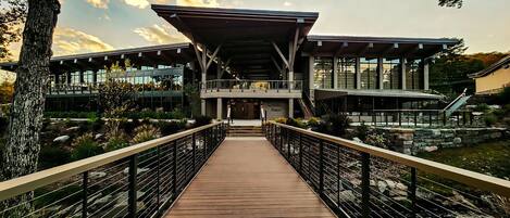 A modern building with a wooden walkway leading to a covered entrance.