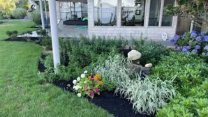 A modern two-story house with a well-maintained garden featuring various plants and flowers. - Sunset Bluff: Breathtaking views of LI Sound. (Northport)