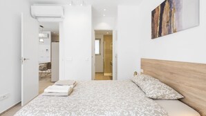 A modern hotel room with a large bed, a wooden headboard, and a painting on the wall. - MAGNIFICENT NEW APARTMENT ADAMA JARDINES DE LOS MENCEYES (Palm-Mar)