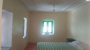 A room with a bed, a window, and a door.