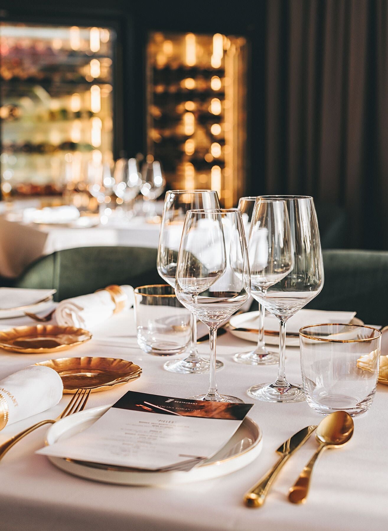 Una mesa dispuesta para una cena formal, con copas de vino, platos y cubiertos.