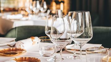 Una mesa dispuesta para una cena formal, con copas de vino, platos y cubiertos.