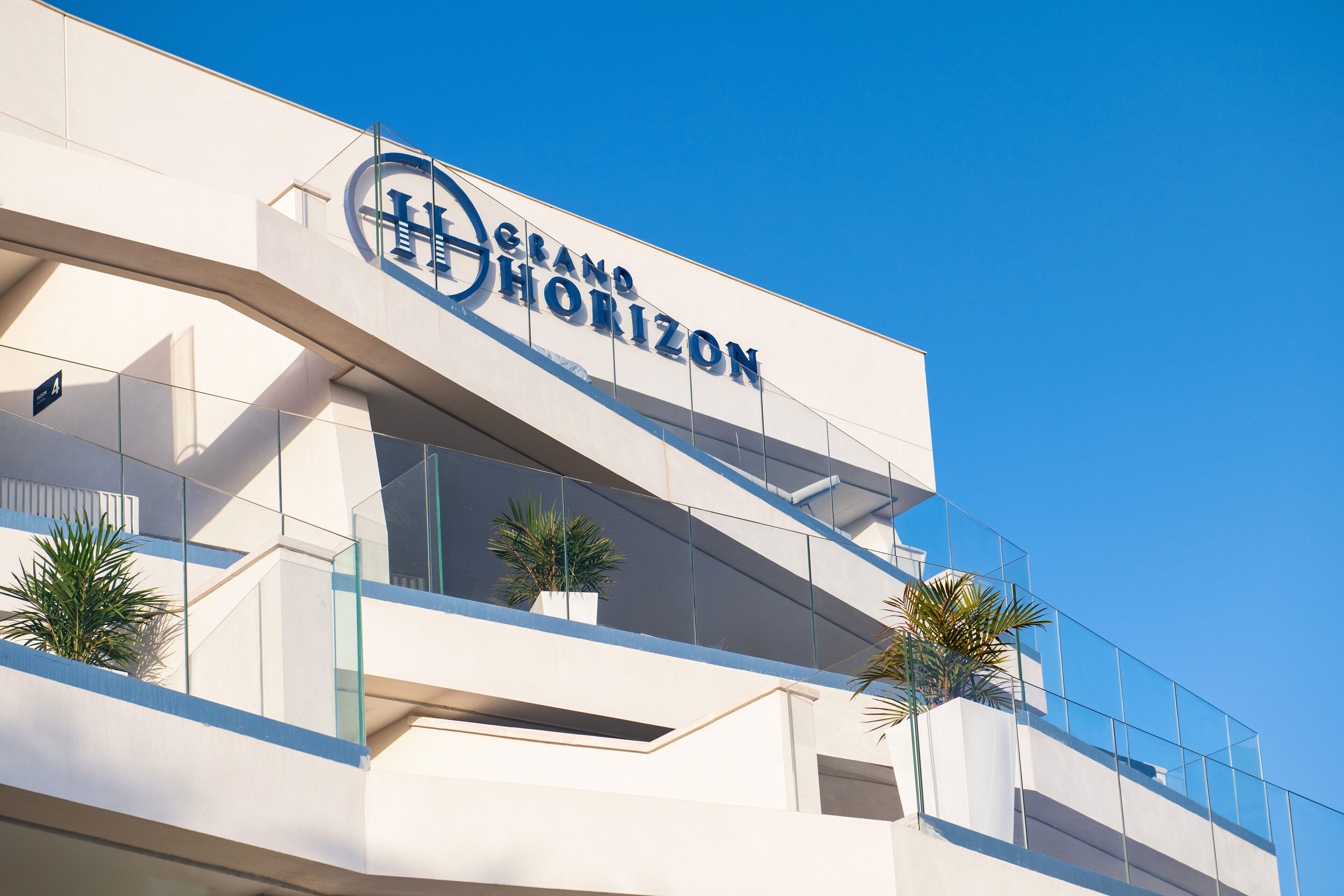 A modern hotel with a prominent sign reading "Grand Horizon".