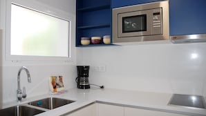 A kitchen with a built-in microwave, a coffee maker, and a sink. - Sunway Arizona (Sitges)