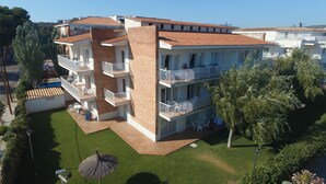 A multi-story hotel with balconies, a swimming pool, and a well-maintained lawn. - Sunway Arizona (Sitges)