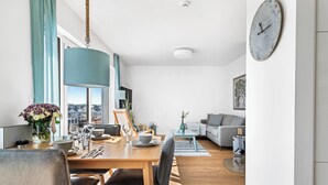 Un salon moderne avec un coin repas, une grande fenêtre et une vue sur la ville.