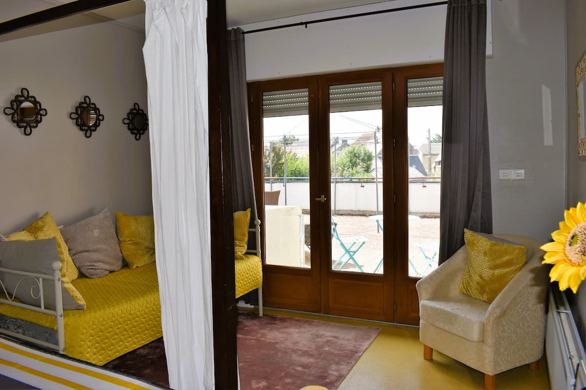 A room with a bed, a chair, and a door leading to an outdoor area.