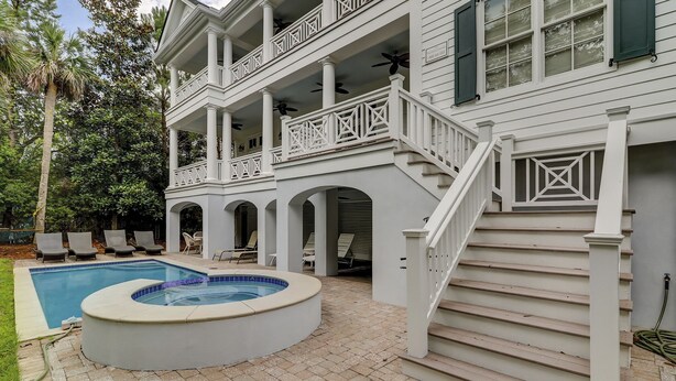 A two-story house with a swimming pool, outdoor seating, and a staircase. - 1 Roadrunner (Hilton Head Island)