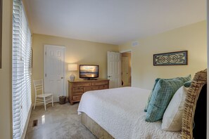 A bedroom with a bed, a television, a dresser, and a chair. - 6 Dinghy (Hilton Head Island)