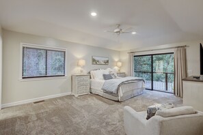 A bedroom with a large window, a ceiling fan, a bed with a canopy, and a view of the outdoors. - 7 Bald Eagle (Hilton Head Island)