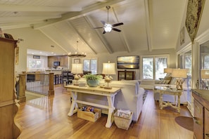A spacious living area with a wooden floor, a dining table, a sofa, and a television displaying 'VACATION INCOMPANY'. - 10 Surf Scoter (Hilton Head Island)