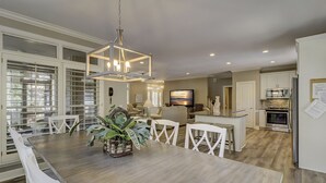 A spacious kitchen with a large island, modern appliances, and a dining area with white furniture. - 1 Sea Oak (Hilton Head Island)