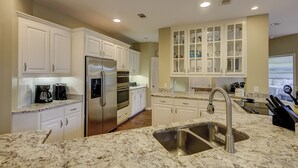Una cocina moderna con armarios blancos, electrodomésticos de acero inoxidable y encimera de granito.