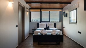 A modern hotel room with a large bed, a wooden ceiling, and a view of the cityscape through large windows.