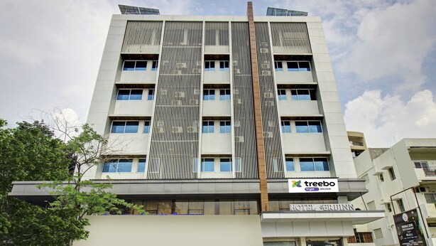 A modern hotel building with a prominent vertical design, multiple balconies, and a sign for 'Treebo Tryst Bruin'. - Treebo Premium Brijinn (Nagpur)