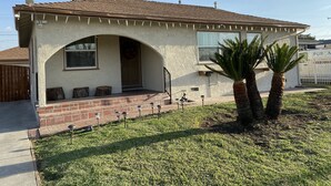 A single-story house with a brick facade, a small porch with benches, and a clear sky. - 2-8 people,3 bedrooms,2 bathrooms, close to Disneyland, safe,quiet,pets friendly (La Puente)
