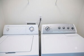 Two front-loading washing machines side by side in a laundry room.