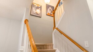 Una escalera con barandillas de madera y un rellano alfombrado.