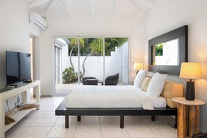 A bedroom with a bed, a TV, a desk, and a chair. - Encore (8 bedrooms) - Lovely villa with pool, Terres Basses, St. Martin (Terres Basses)