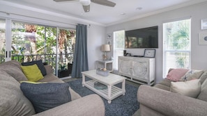A living room with a sofa, a coffee table, a TV, and a cabinet.