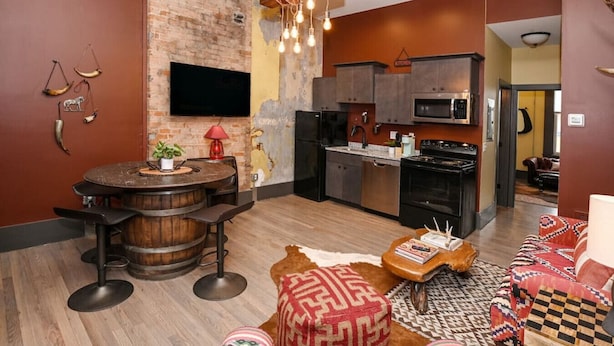 A modern kitchen with a microwave, stove, and a hanging light fixture. - Rodeo Red | OTR Cincinnati (Cincinnati)
