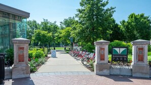 A pathway leading to Washington Park with a bike rack and a sign. - Rodeo Red | OTR Cincinnati (Cincinnati)