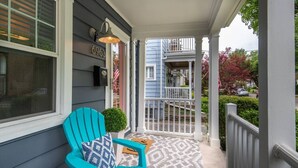 A porch with a turquoise chair and a small potted plant. - Lower Cambridge · Cozy Cambridge (Cincinnati)