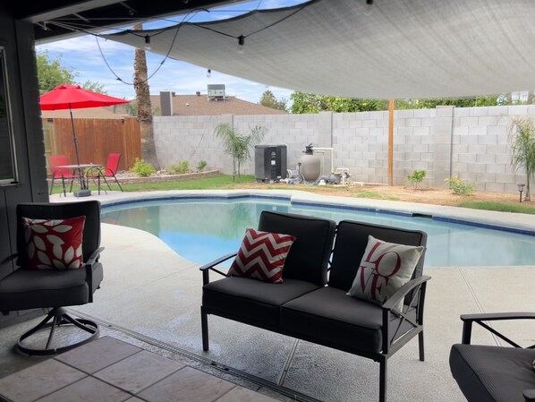 A covered patio with a pool, outdoor furniture, and a view of the backyard. - New family retreat w/private heated pool and hot tub (Chandler)