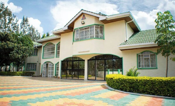 A two-story building with a large entrance and a colorful tiled ground.