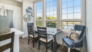 Une cuisine équipée d’une table à manger, de chaises, d’un réfrigérateur et d ’une fenêtre donnant sur un beau paysage.