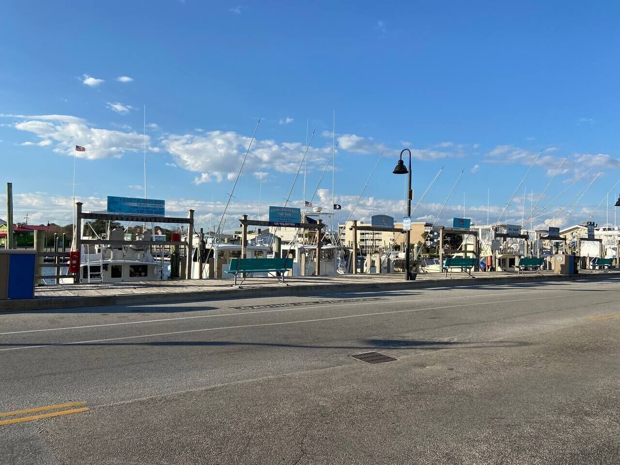 Un port de plaisance avec des bateaux amarrés, une station-service et un ciel bleu dégagé.