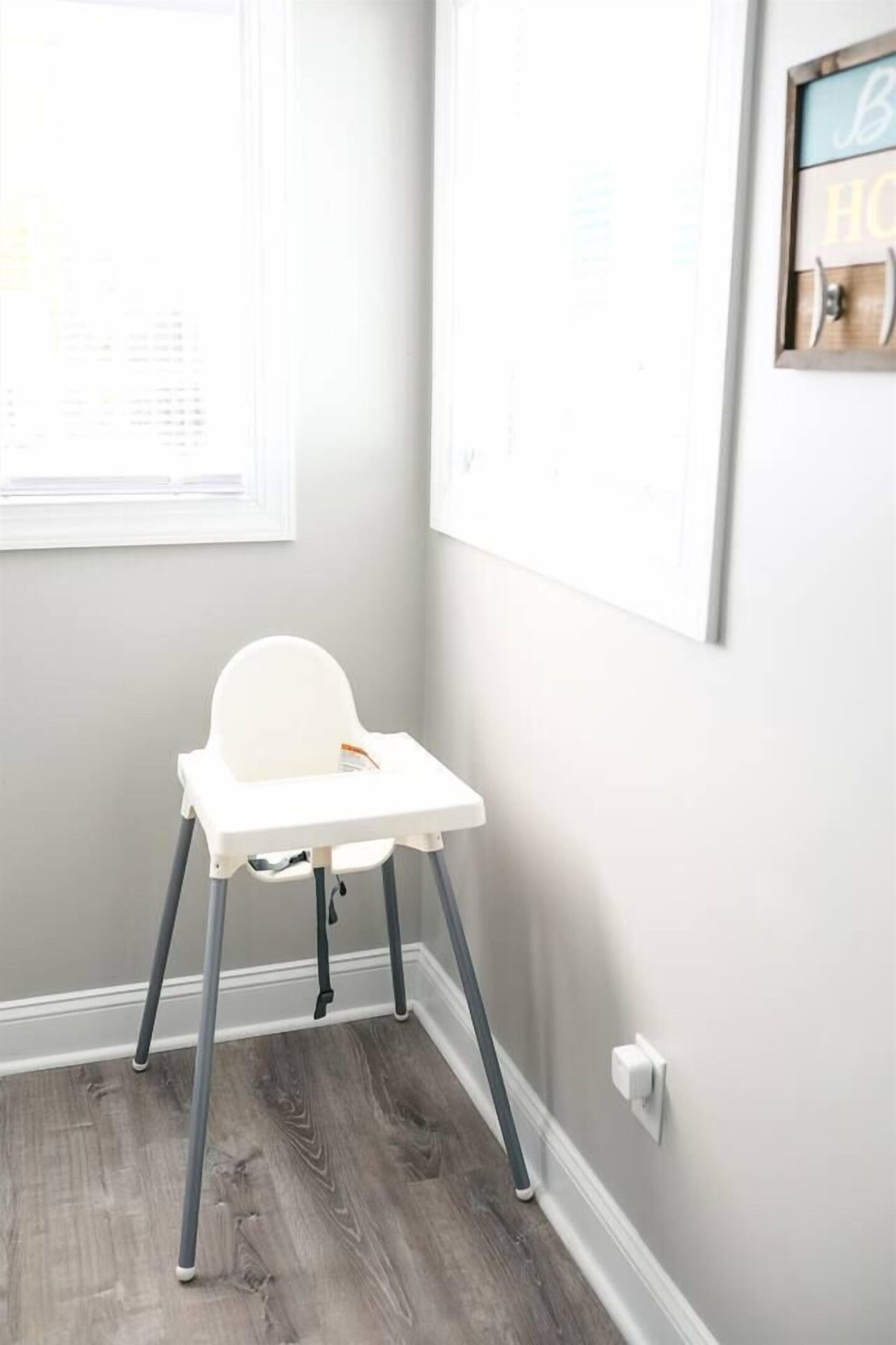 Une pièce avec une chaise blanche, un tableau blanc et une fenêtre.