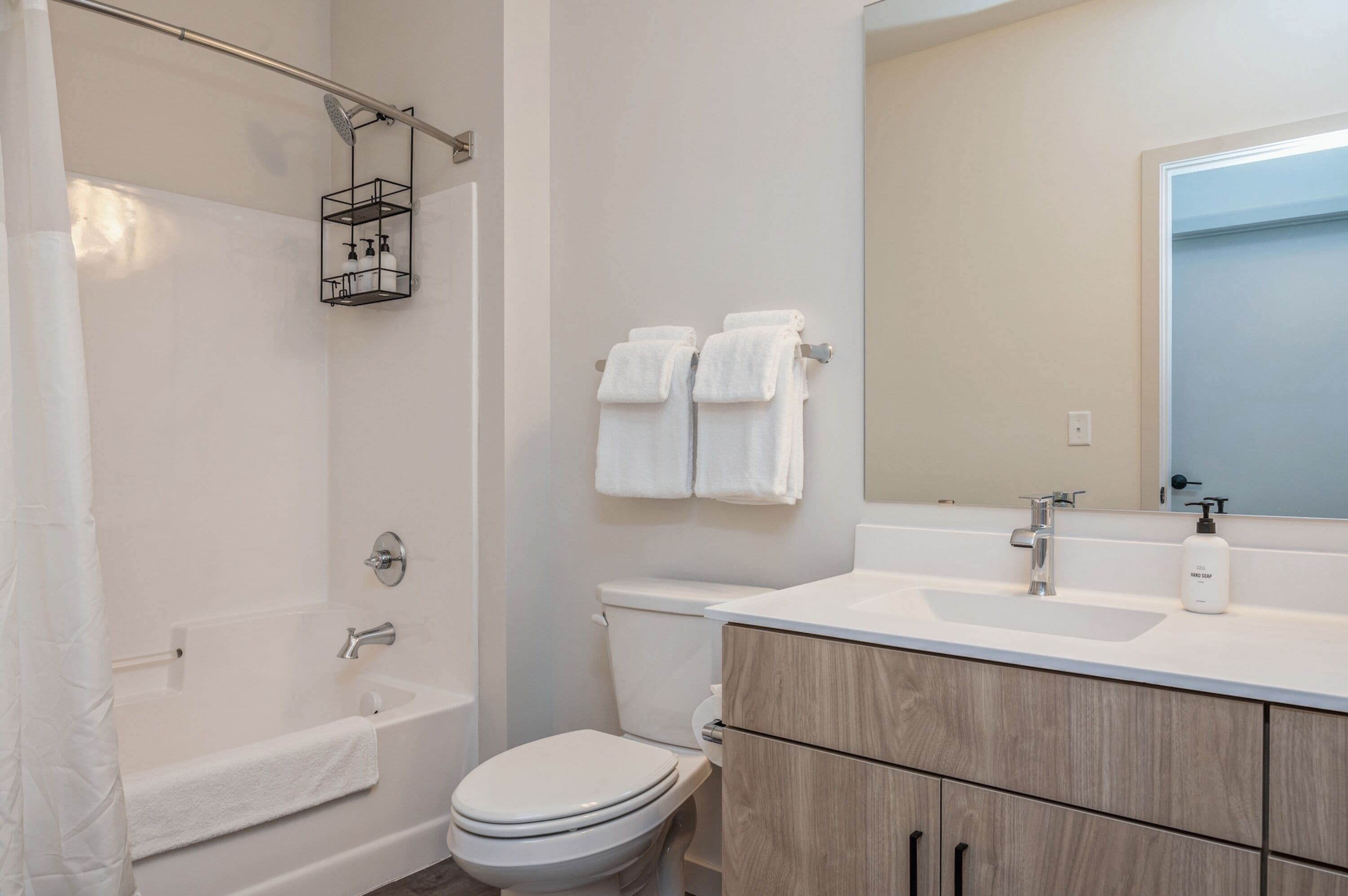 A modern bathroom with a bathtub, toilet, and sink.