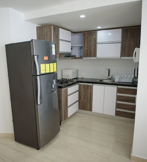 Eine moderne Küche mit einem Edelstahlkühlschrank, einer Mikrowelle und einem Herd.