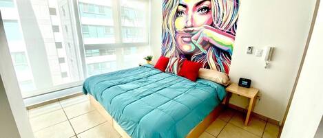 Un dormitorio moderno con una cama grande, un cuadro de colores en la pared y una ventana con vistas a la ciudad.
