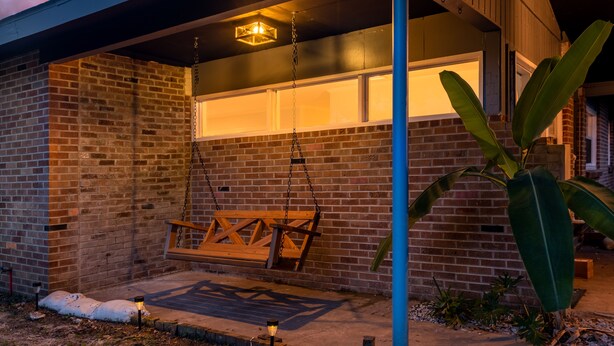Um edifício de tijolos com balanço e luminária pendente.
