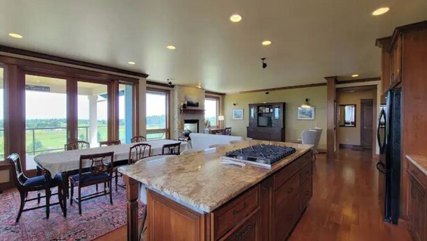 A spacious kitchen with a large island, wooden cabinets, and a view of the outdoors. - Executive House Suite with Gorgeous Olympic Views (Port Angeles)