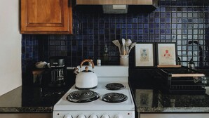 Una cocina con estufa blanca, encimeras negras y armarios de madera.