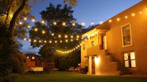 A house with a covered porch, a small deck, and a string of lights.