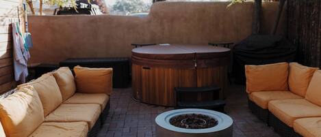 Un espacio al aire libre con una mesa redonda y dos sofás.