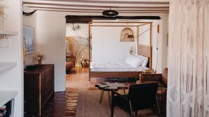 A bedroom with a bed, a wooden dresser, a chair, and a small table. - Hot Tub + Pool! Coyote Suite at The Desert Compass in Old Town (Albuquerque)