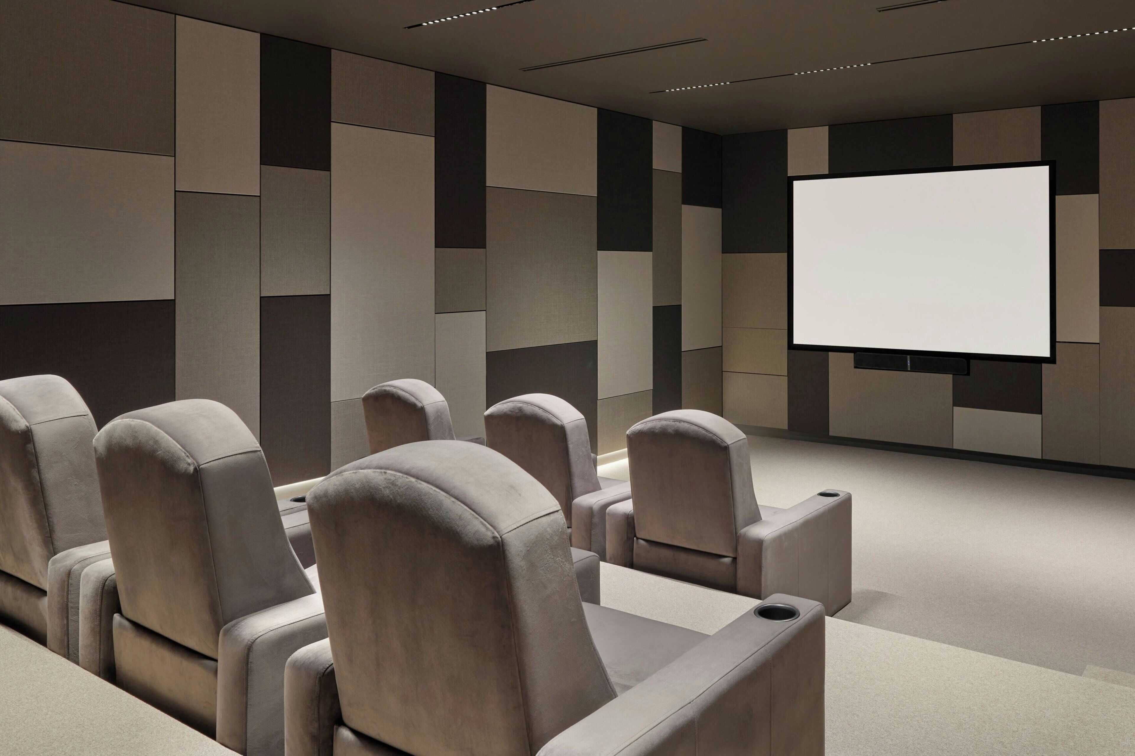 Una sala de cine moderna con asientos cómodos y una pantalla grande.