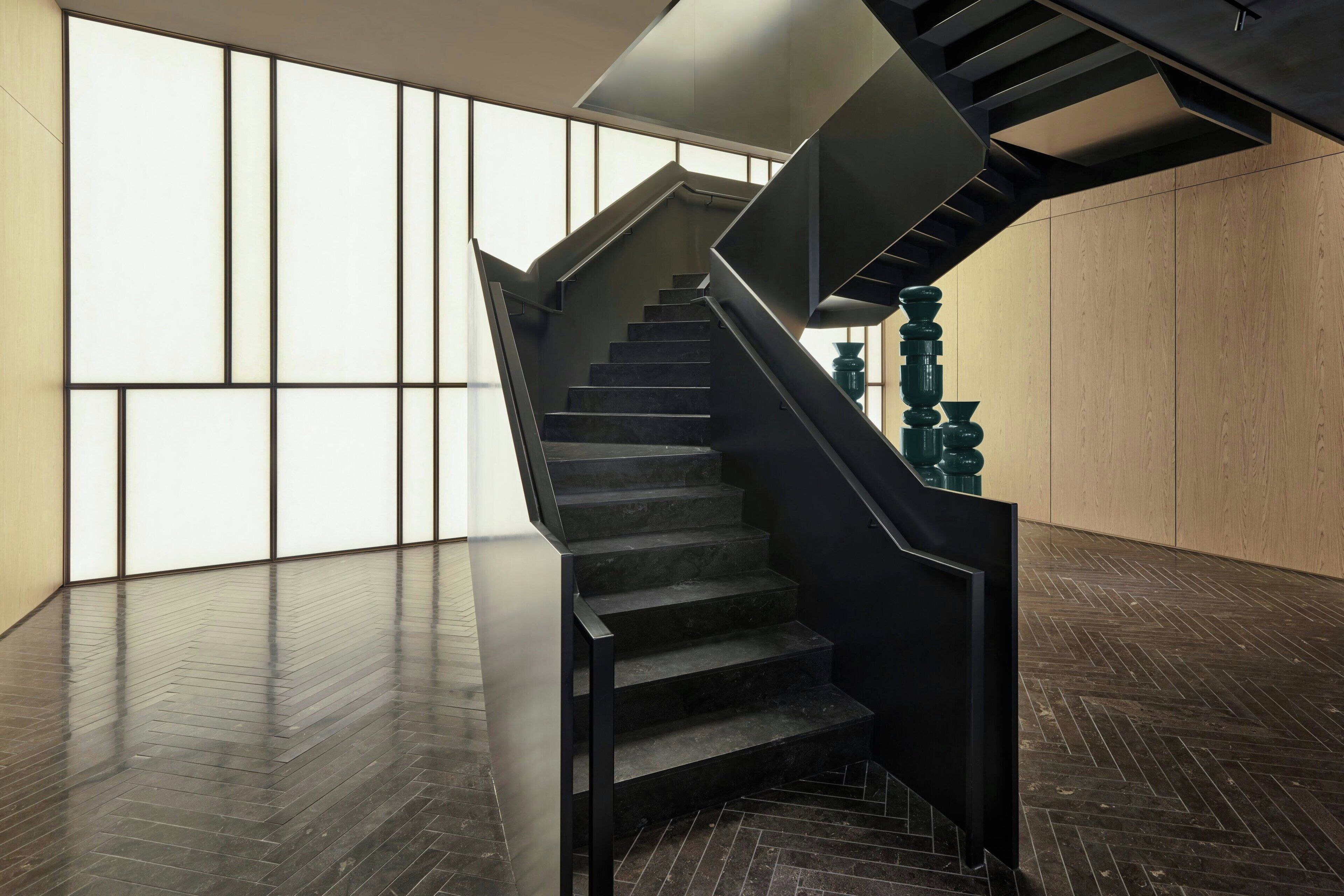 A modern staircase with a dark finish, leading to a higher floor.