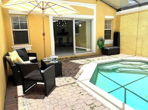 A pool area with a patio, outdoor furniture, and a sliding glass door leading to an interior space. - Yellow Lantana-Winnie Themed🐻Resort🍯Townhome close to the Parks w Private pool (Kissimmee)