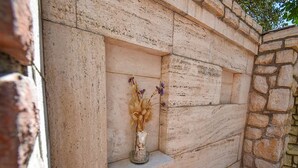 A stone wall with a built-in shelf containing a vase with dried flowers. - Apartments Jaklin - Two Bedroom Apartment with Terrace and Sea View (Rab)