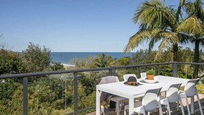 A deck with a table and chairs overlooking a coastal view. - Stunning Beach Views With Pool. Easy Walk To Beach (KILLCARE)