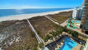 Un resort con vista a la playa, piscina y paseo marítimo.