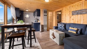A cozy cabin interior with a dining area, kitchen, and living space. - Cozy cabin steps from the lake! (Brainerd)