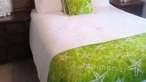 Una habitación de hotel con una cama, dos mesitas de noche y una mesita auxiliar.